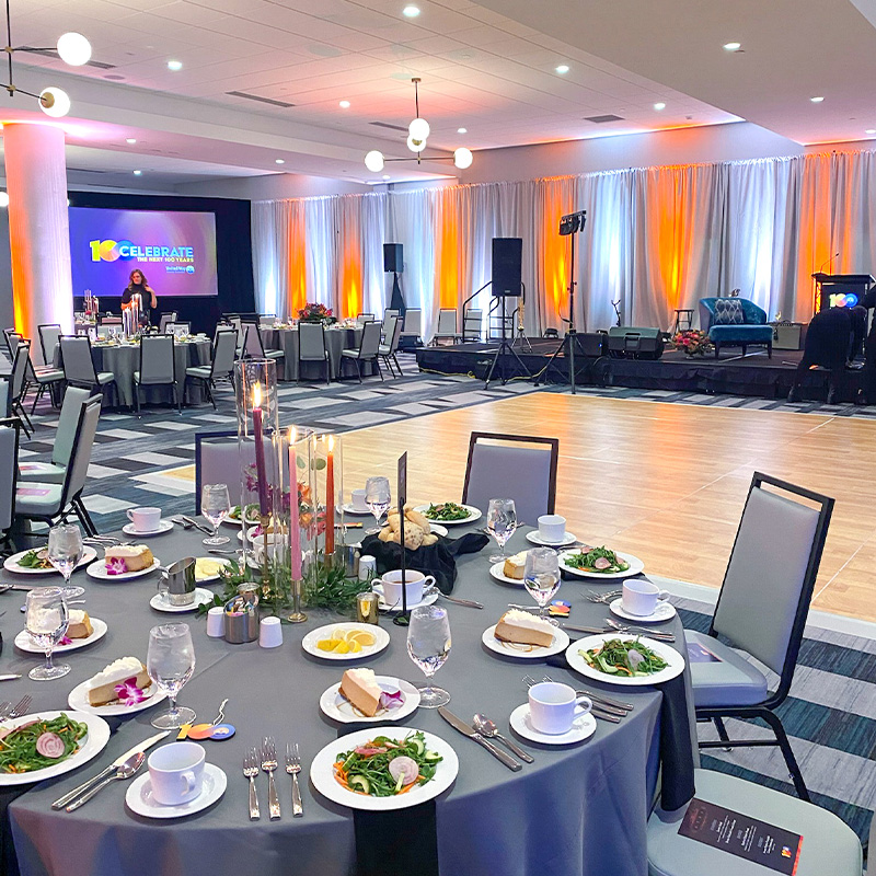 modern conference room with dramatic uplighting and tables set with salad and dessert