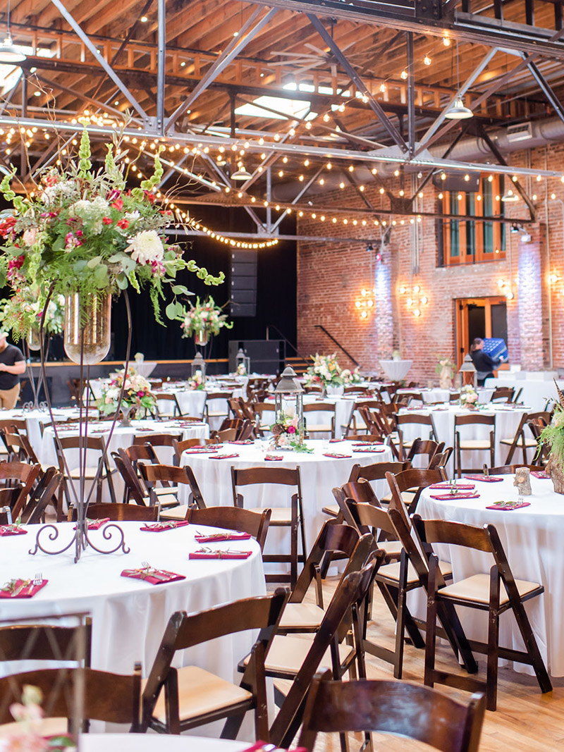 tables set for a gala dinner at the Mill and Mine in Knoxville, TN with dramatic floral arrangements