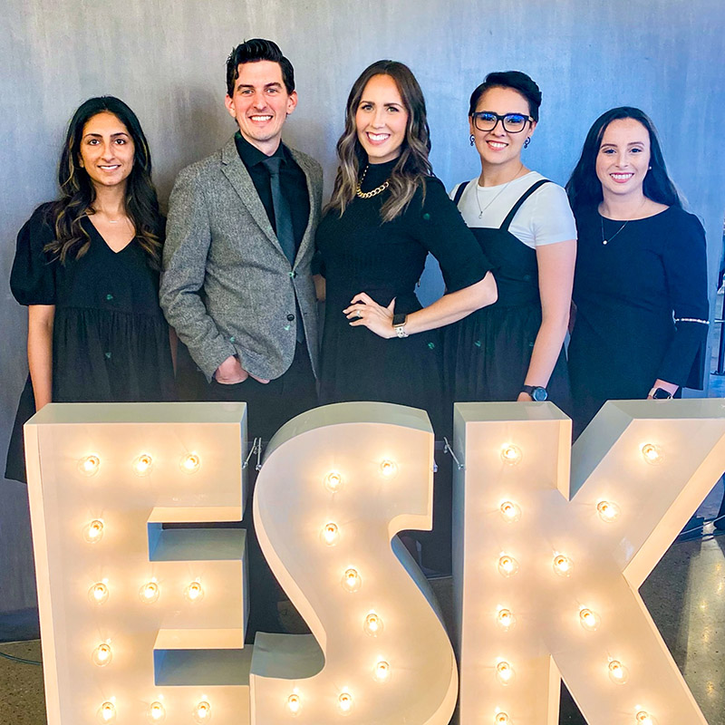 Holloway Event Co. team standing in front of a lit sign for Episcopal School of Knoxville