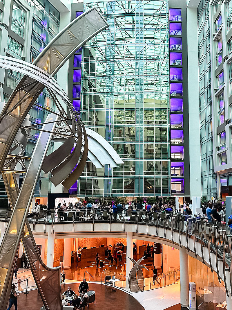 multi-story atrium at a hotel with people mingling for a business conference